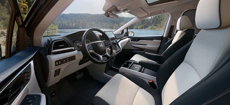 2027 Honda Odyssey Elite front cabin featuring perforated leather seats and dashboard (Minivan).