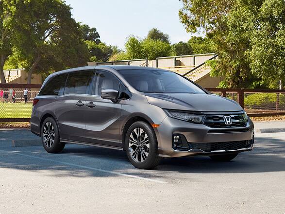 Front view of the 2027 Honda Odyssey minivan Elite in Modern Steel Metallic parked outdoors (Minivan).